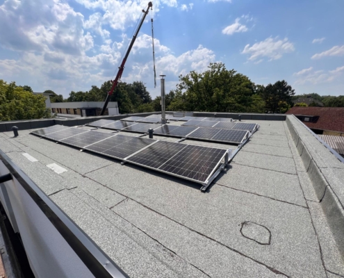 Flachdacharbeiten mit neuer Abdichtung und PV-Anlage Flachdach mit frisch abgedichteter Oberfläche und montierter Photovoltaikanlage bei sonnigem Wetter
